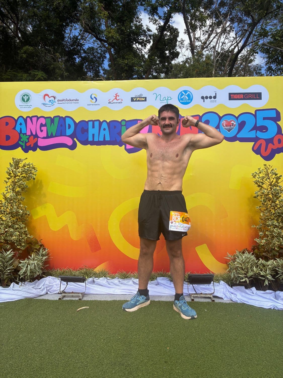Sam Rigg after losing 85kg, flexing after a charity run in Phuket