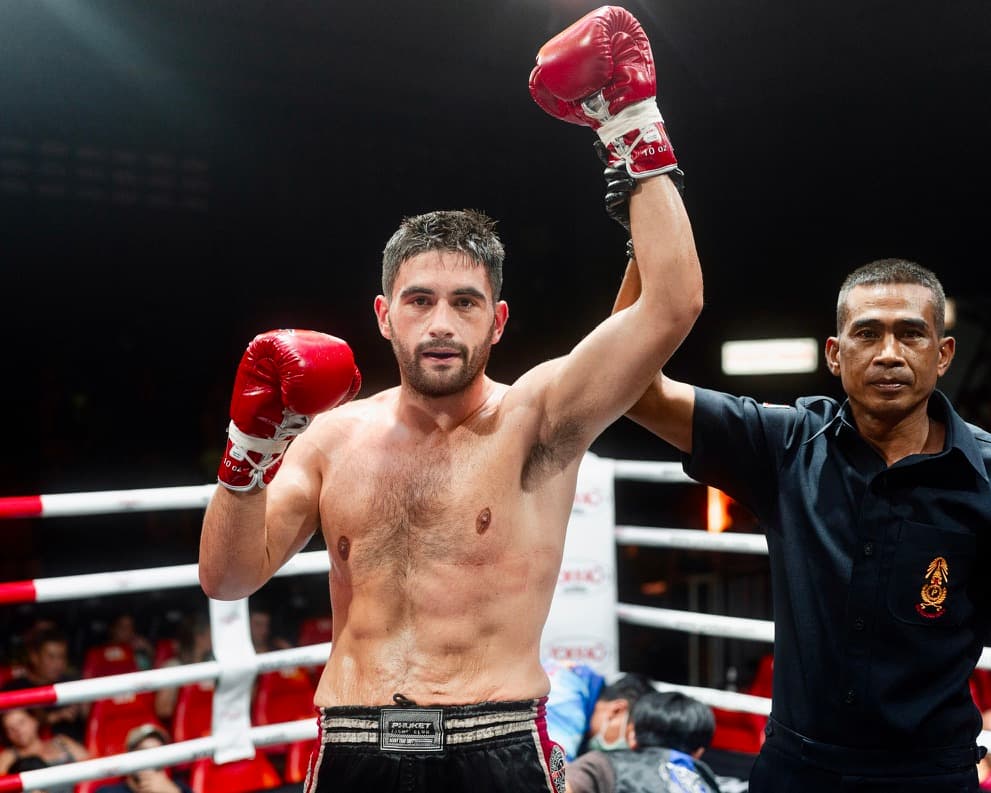 Sam Rigg with his arm raised after a Muay Thai win in Phuket